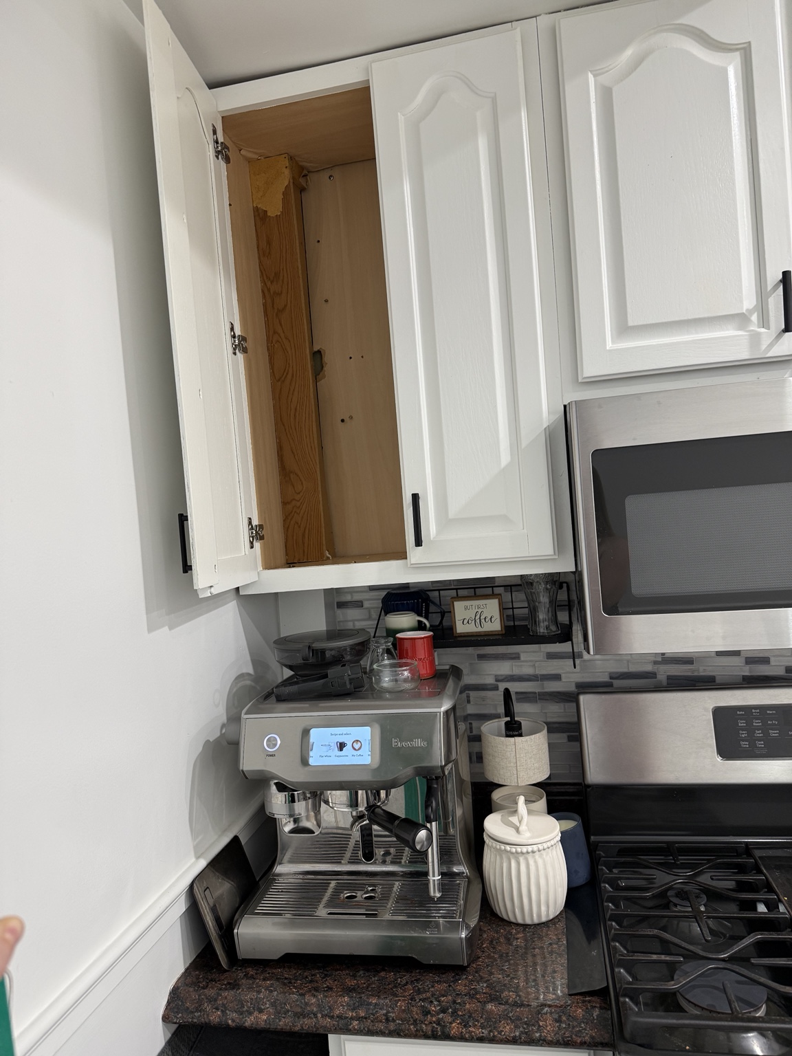 Before: white upper kitchen cabinet above a countertop espresso machine
